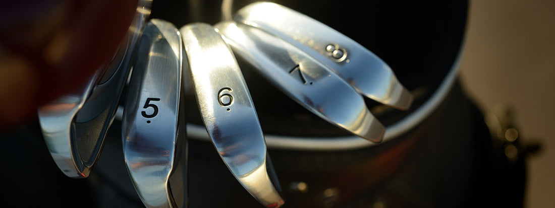 Close-up of golf club heads with numbers on a blurred background