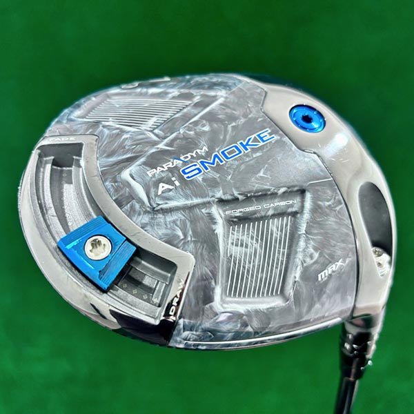 Golf club head with 'Paradym Smoke' branding on a green background