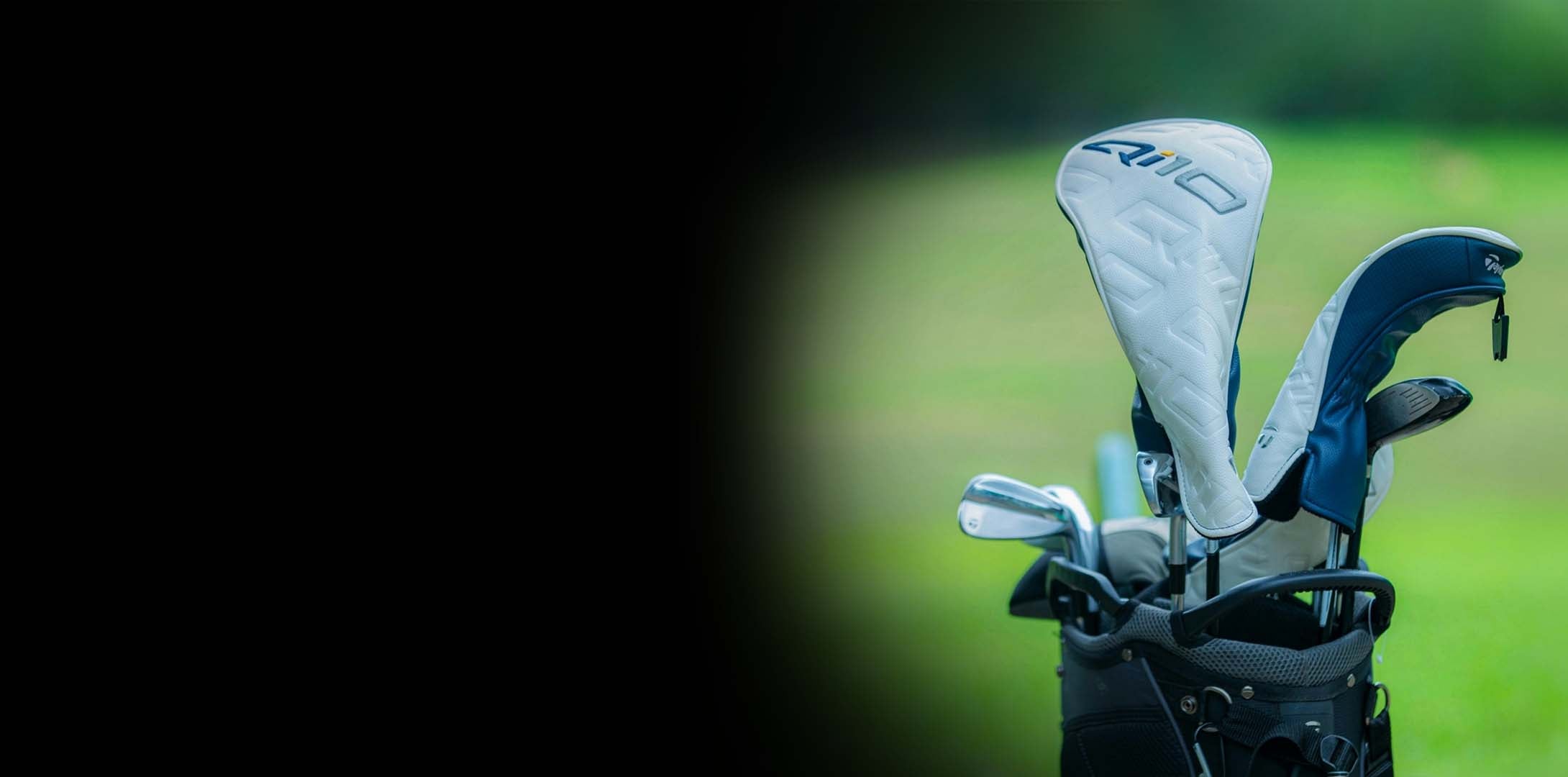 Close-up of golf clubs with a focus on the head covers on a blurred green background