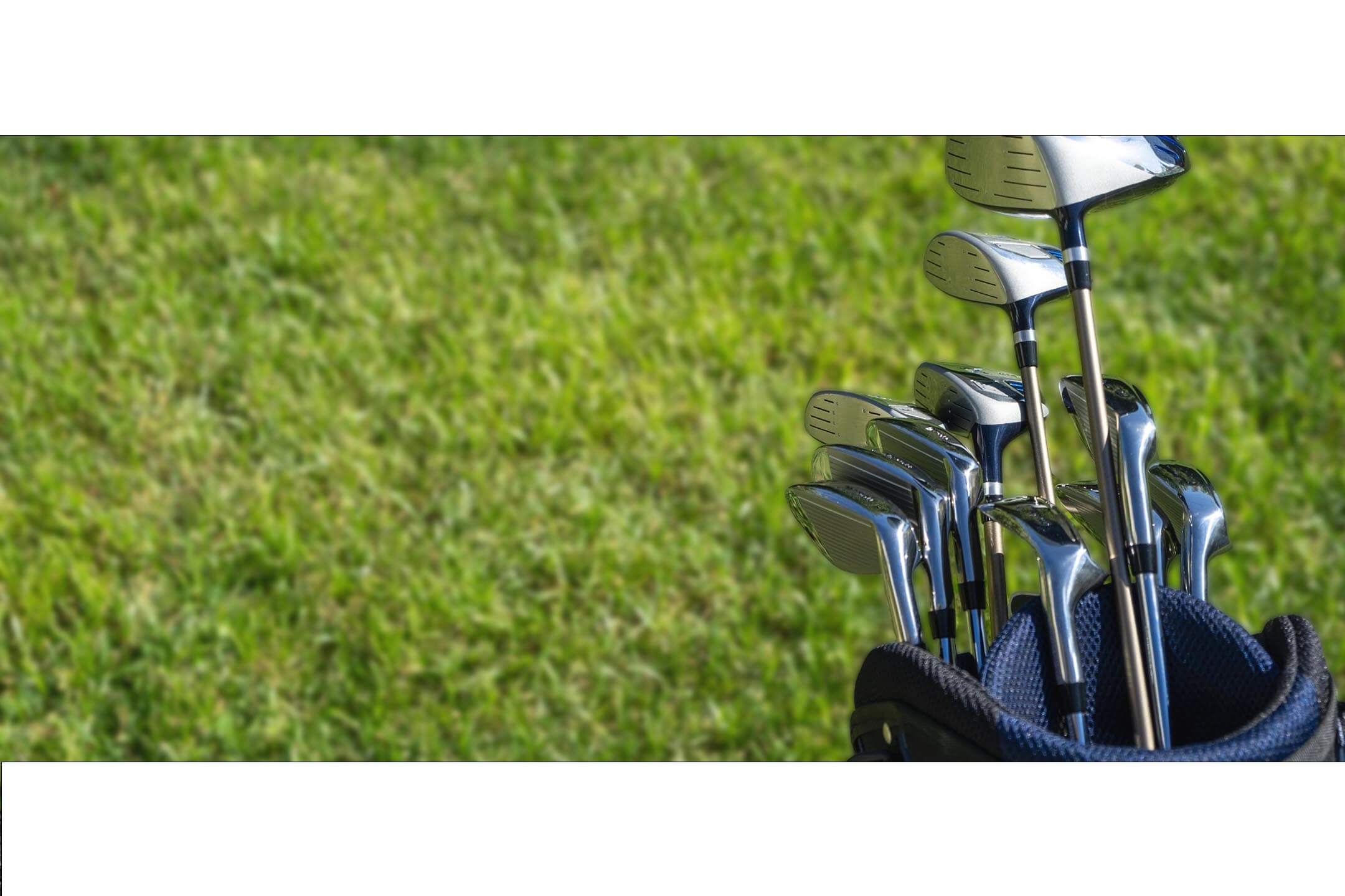 Set of golf clubs in a bag with grass in the background