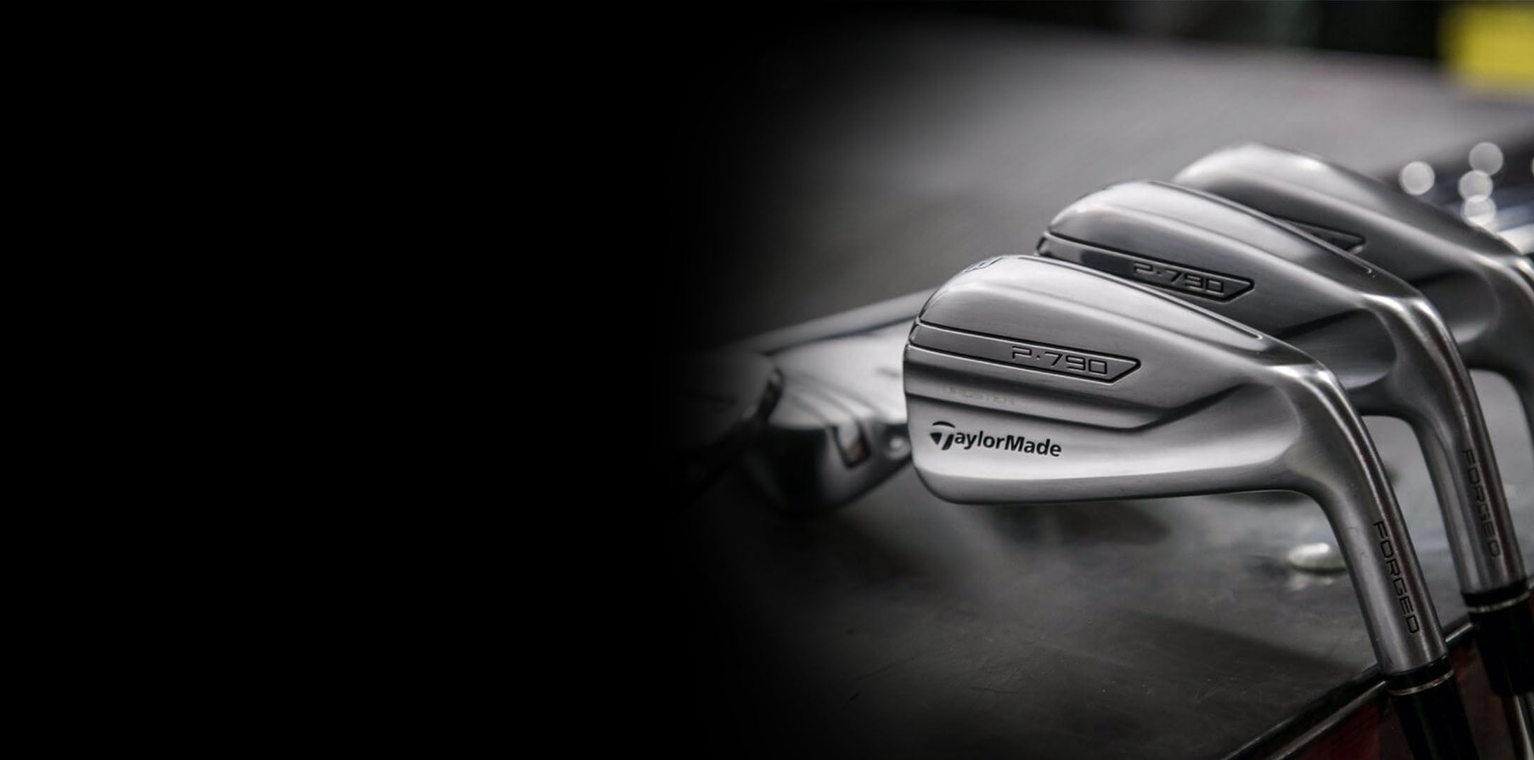 Close-up of golf clubs with TaylorMade logo on a dark background