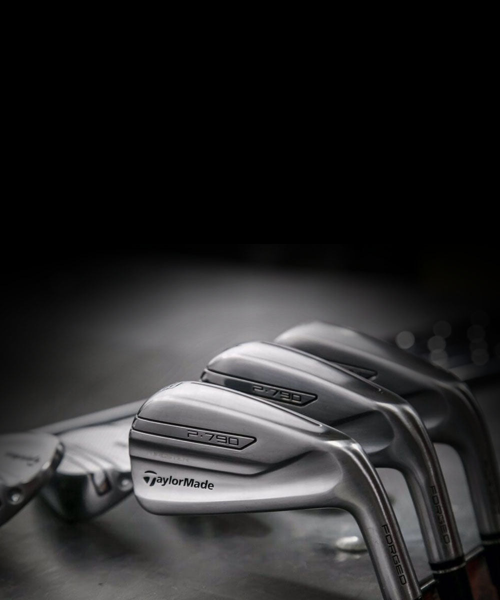 Close-up of TaylorMade golf clubs on a dark background