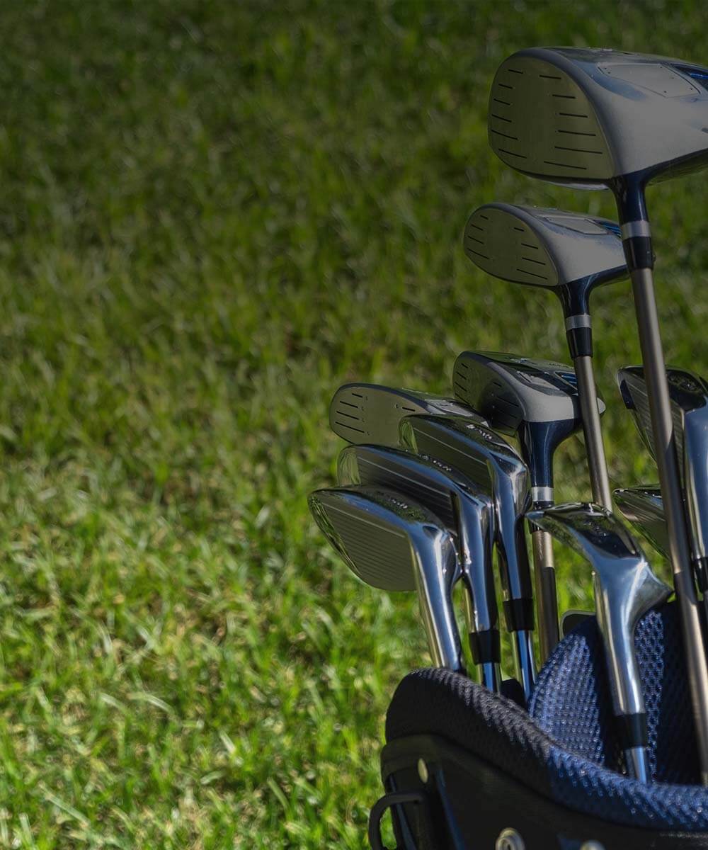 Set of golf clubs in a bag with grass in the background