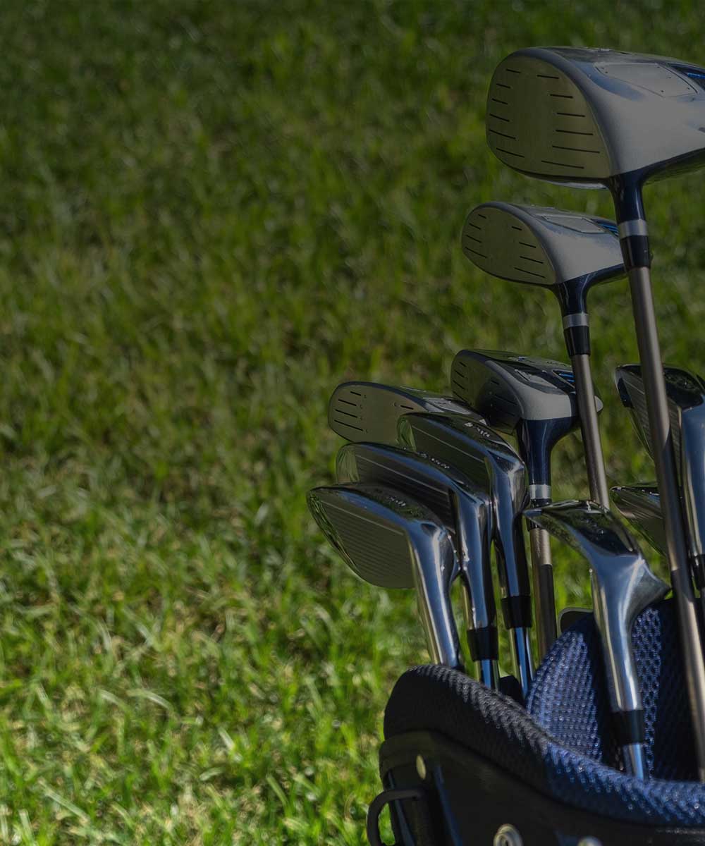 Set of golf clubs in a blue club bag on a grassy background