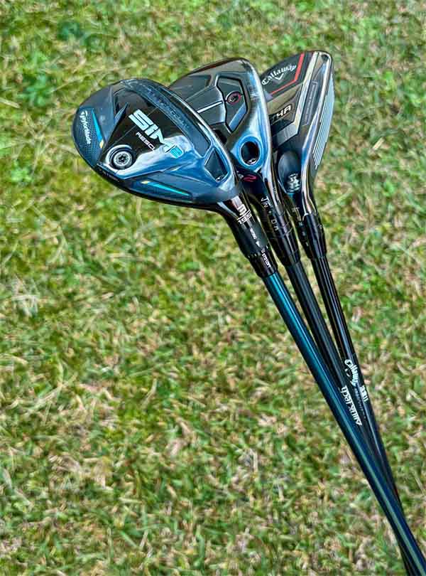 Three golf clubs on a grassy background